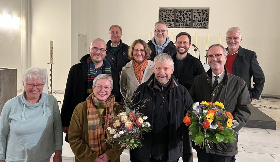 Eine Gruppe fröhlicher Menschen steht in einer Kirche.