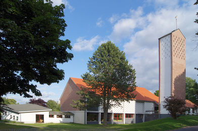 Außenansicht der Auferstehungskirche mit umliegenden Bäumen und Wiese - Copyright: Manfred Maronde