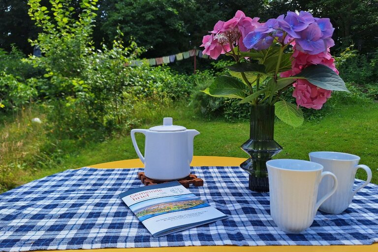 Sommerliche Gartenszene mit dem neuen Gemeindebrief