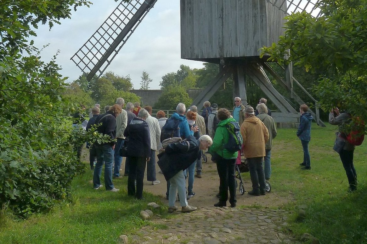 lockere Gruppe von Gemeindemitgliedern, die sich die Bock-Windmühle in Molfsee anschauen